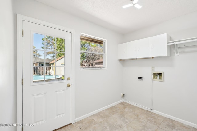 laundry area with baseboards, hookup for a washing machine, cabinet space, electric dryer hookup, and a textured ceiling