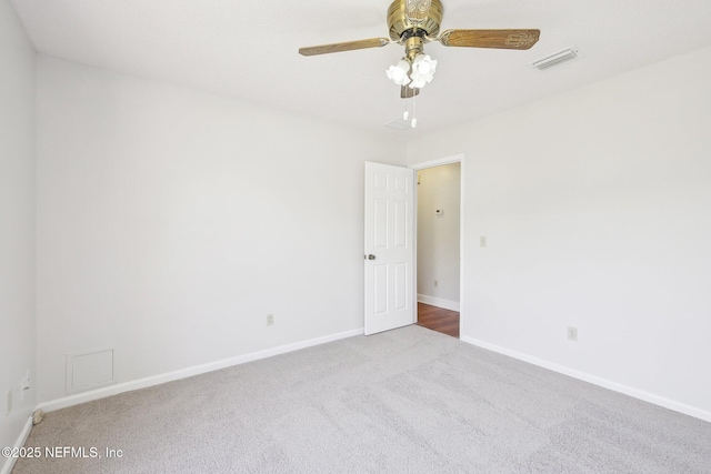 empty room with a ceiling fan, carpet, visible vents, and baseboards