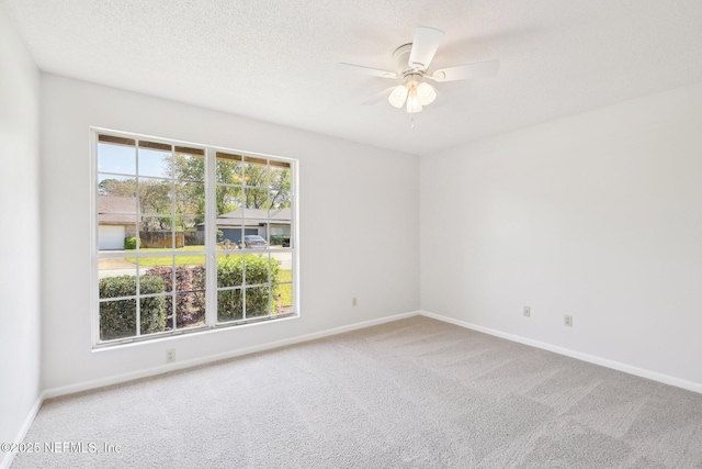 unfurnished room featuring a ceiling fan, baseboards, a textured ceiling, and carpet flooring