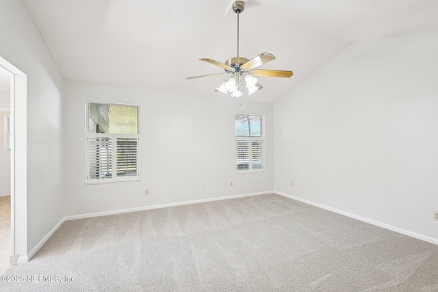 carpeted spare room with baseboards, a ceiling fan, and lofted ceiling