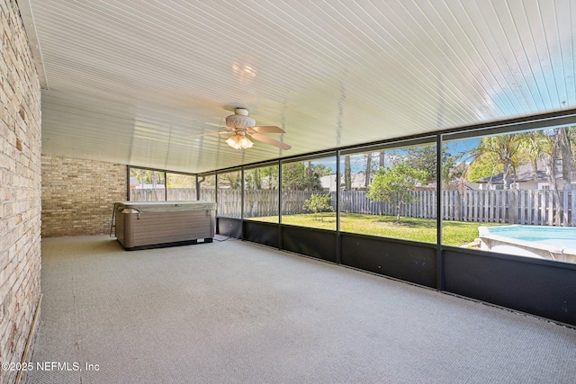 unfurnished sunroom featuring a healthy amount of sunlight and a ceiling fan