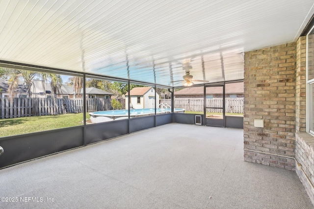 unfurnished sunroom featuring a ceiling fan