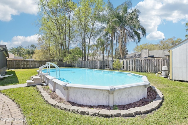 view of swimming pool featuring a fenced in pool, a lawn, and a fenced backyard