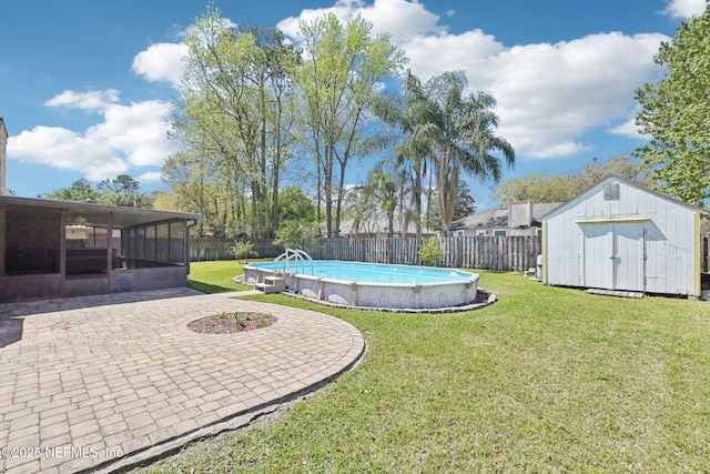 view of yard featuring an outbuilding, a patio, a fenced backyard, a sunroom, and a storage unit