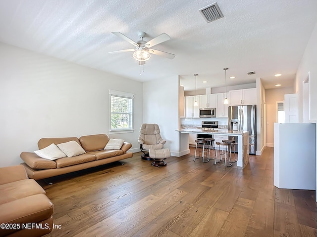 31 Lewis Blvd, Saint Augustine, FL 32084 - living area with a ceiling fan, dark wood-style floors, visible vents, and a textured ceiling