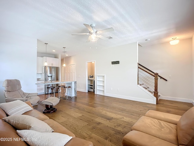 31 Lewis Blvd, Saint Augustine, FL 32084 - living area with baseboards, stairs, wood finished floors, a textured ceiling, and a ceiling fan