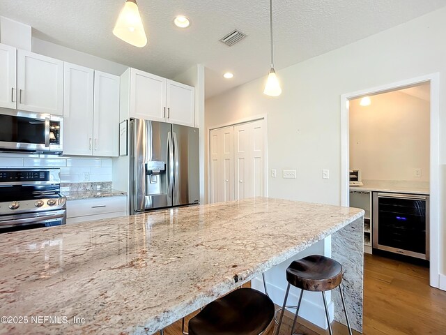 31 Lewis Blvd, Saint Augustine, FL 32084 - kitchen featuring beverage cooler, visible vents, a breakfast bar, appliances with stainless steel finishes, and pendant lighting