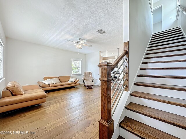 31 Lewis Blvd, Saint Augustine, FL 32084 - living area featuring stairway, a ceiling fan, visible vents, wood-type flooring, and a textured ceiling