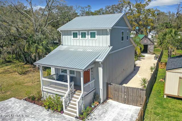 31 Lewis Blvd, Saint Augustine, FL 32084 - view of front of house with an outdoor structure, a storage unit, fence, and covered porch