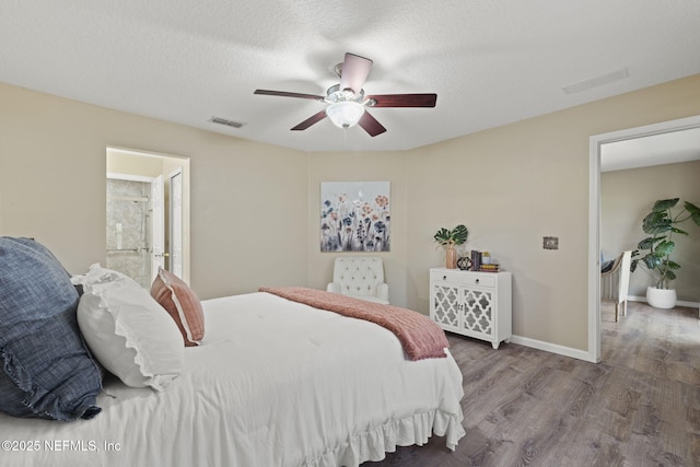 bedroom featuring wood finished floors, visible vents, baseboards, ceiling fan, and a textured ceiling