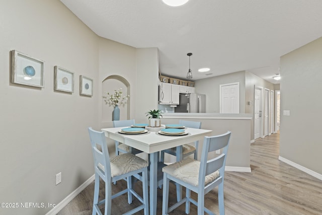 dining room featuring light wood-type flooring and baseboards