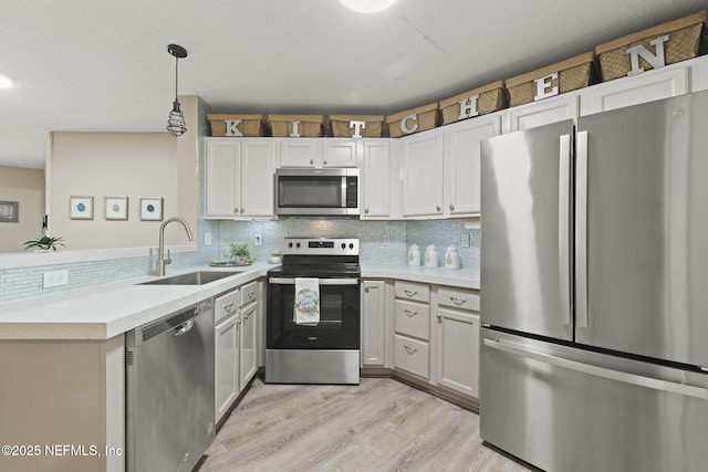 kitchen with a sink, stainless steel appliances, tasteful backsplash, and light countertops