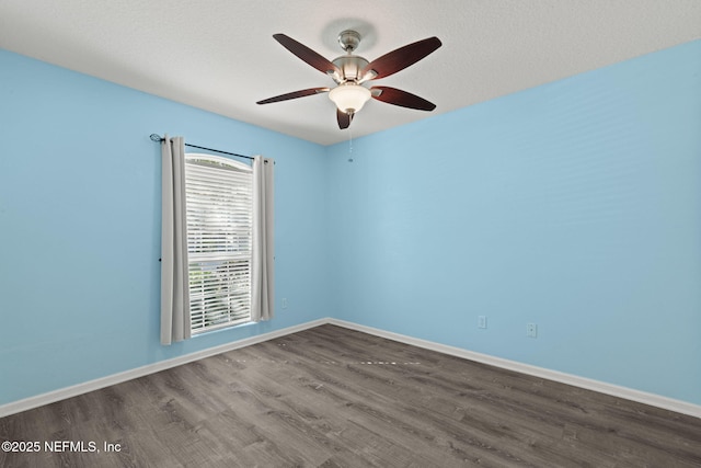 spare room with baseboards, wood finished floors, a textured ceiling, and ceiling fan