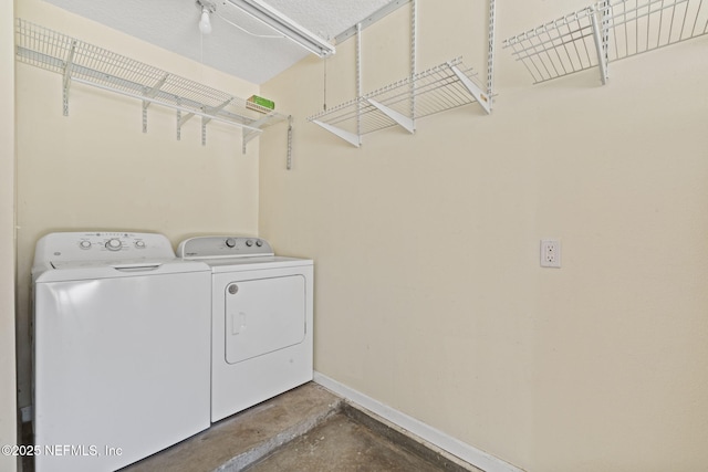 washroom featuring washer and dryer, baseboards, and laundry area