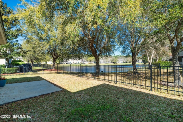 view of yard featuring a water view, a patio, and fence