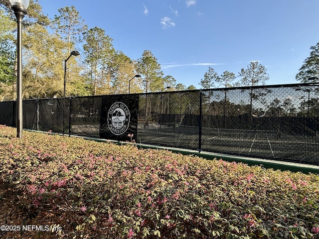 view of tennis court featuring fence