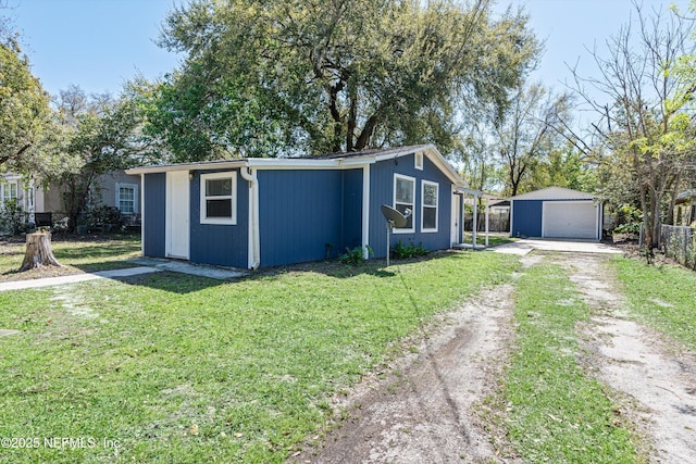 view of outbuilding with an outdoor structure, fence, and driveway