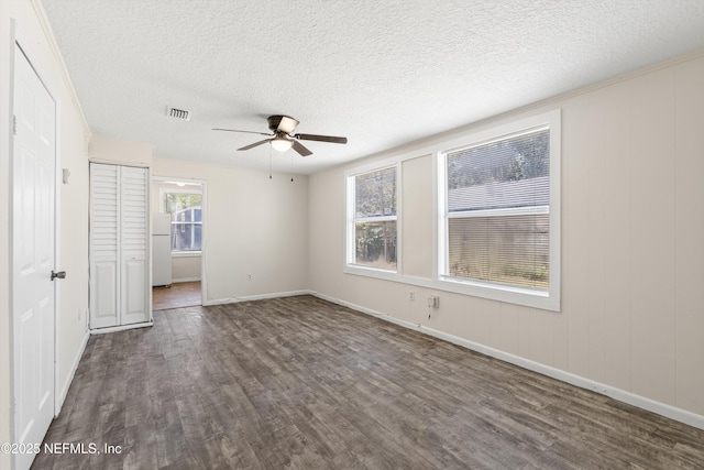 unfurnished room featuring visible vents, a textured ceiling, a ceiling fan, and wood finished floors