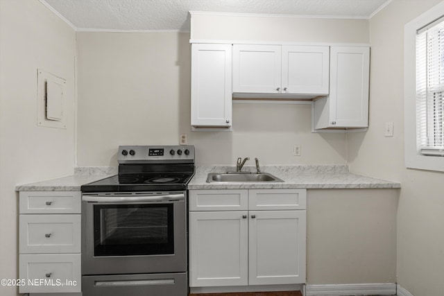 kitchen featuring stainless steel electric stove, a textured ceiling, light countertops, and a sink