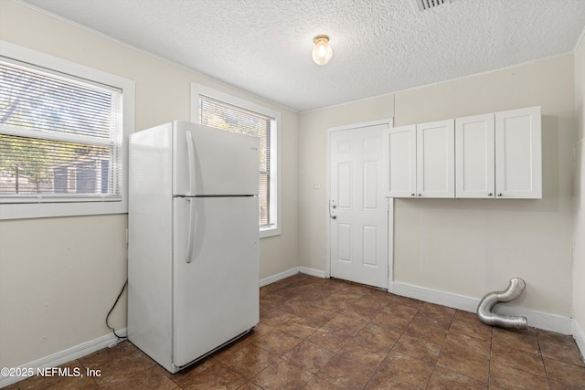 washroom featuring a textured ceiling and baseboards