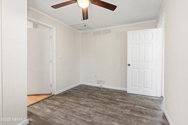 empty room with ornamental molding, wood finished floors, visible vents, and ceiling fan