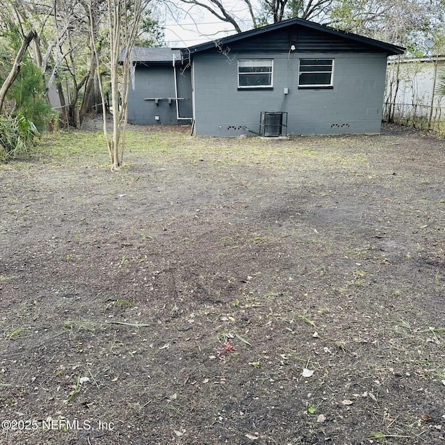 view of side of home featuring concrete block siding and central air condition unit