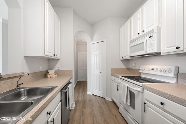 kitchen with light wood-type flooring, a sink, white cabinetry, white appliances, and arched walkways