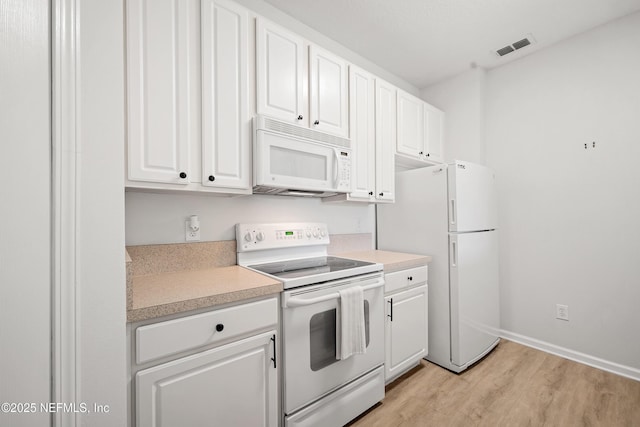 kitchen with visible vents, light countertops, light wood-style flooring, white appliances, and white cabinetry