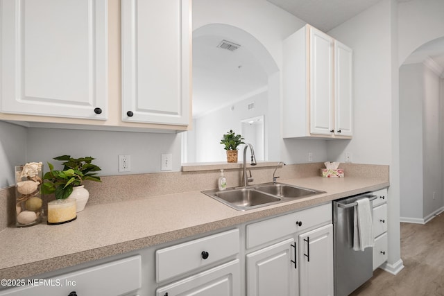 kitchen with visible vents, a sink, white cabinetry, arched walkways, and dishwasher