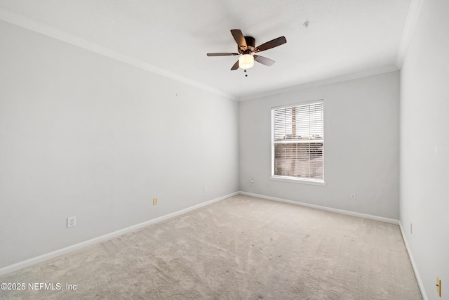 carpeted empty room with ceiling fan, crown molding, and baseboards