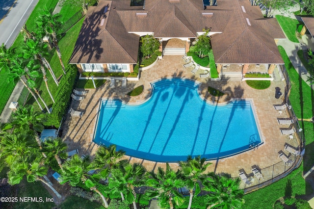 community pool with a patio and fence