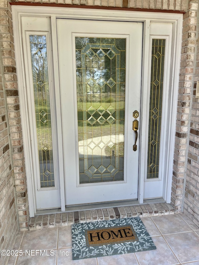 doorway to property with brick siding