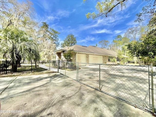 view of home's exterior featuring concrete driveway, a gate, fence, and a garage