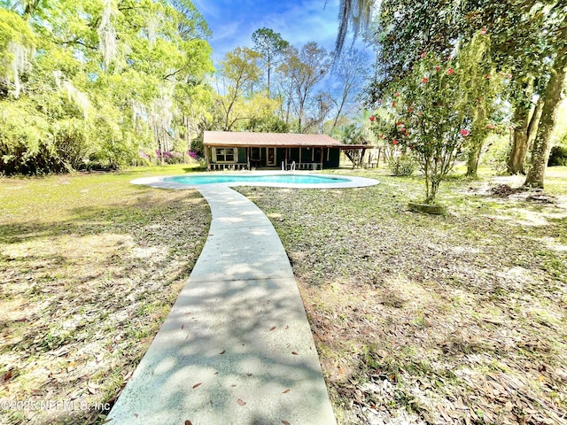 exterior space with a yard and an outdoor pool