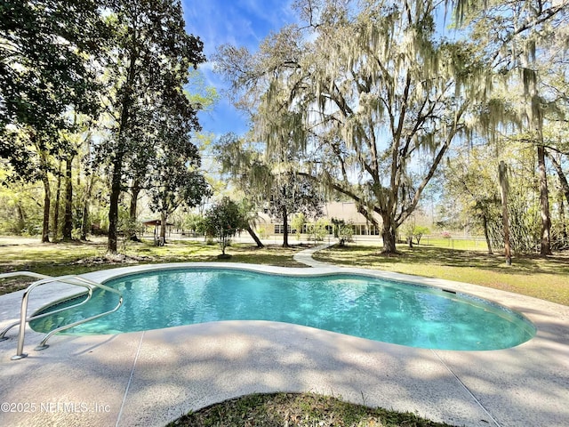 outdoor pool featuring a lawn