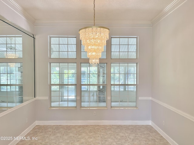 spare room featuring ornamental molding, a healthy amount of sunlight, and a chandelier