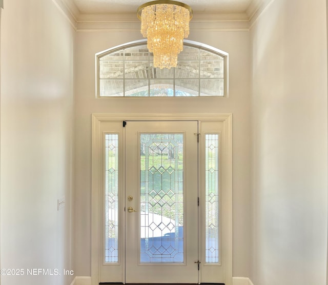 entrance foyer featuring an inviting chandelier and ornamental molding