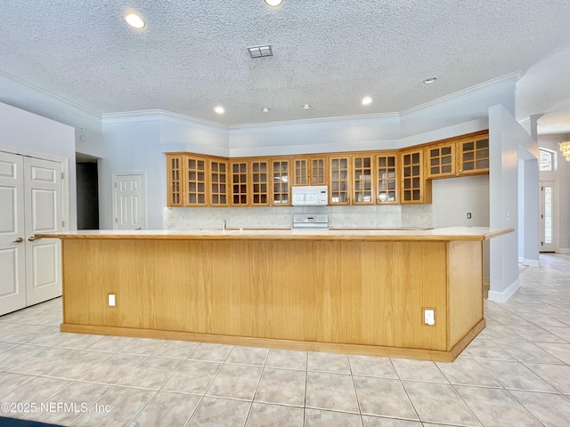 kitchen featuring white microwave, visible vents, glass insert cabinets, and range