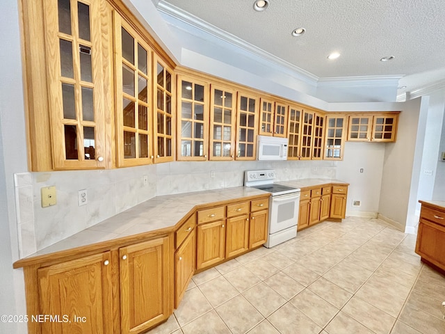 kitchen featuring tile countertops, glass insert cabinets, white appliances, and crown molding