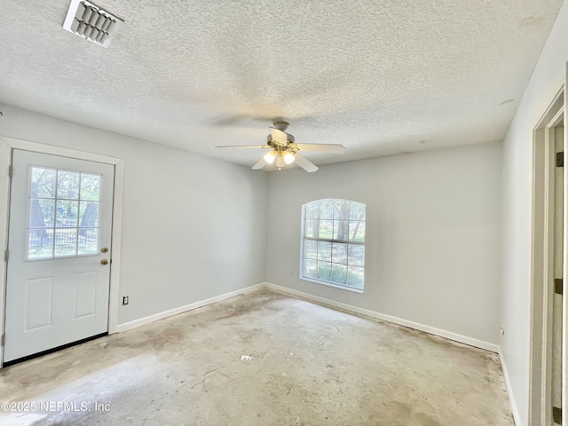 empty room featuring visible vents, a ceiling fan, a textured ceiling, baseboards, and unfinished concrete floors