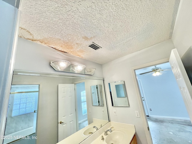 bathroom featuring a wealth of natural light, visible vents, a textured ceiling, and vanity