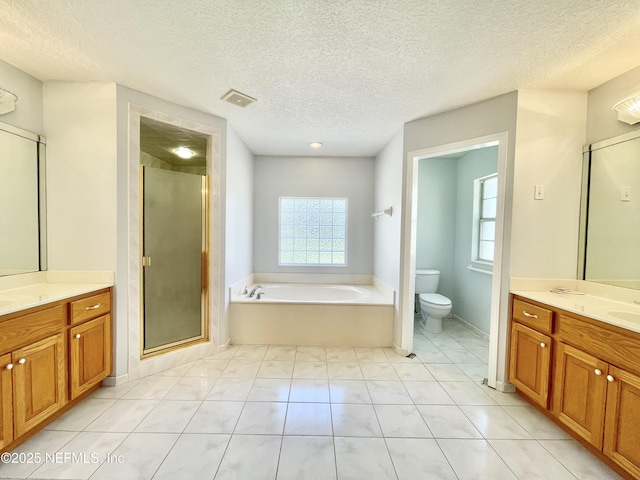 bathroom featuring visible vents, toilet, two vanities, and a stall shower