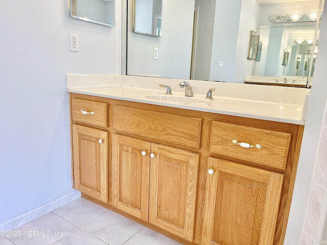 bathroom with vanity, tile patterned floors, and baseboards