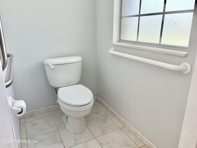 bathroom featuring tile patterned flooring, toilet, and baseboards