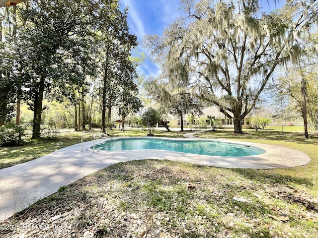 view of swimming pool with a yard