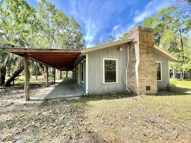 view of side of home with a carport and a chimney