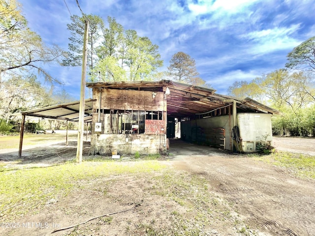 view of outbuilding featuring a carport, an outdoor structure, and driveway