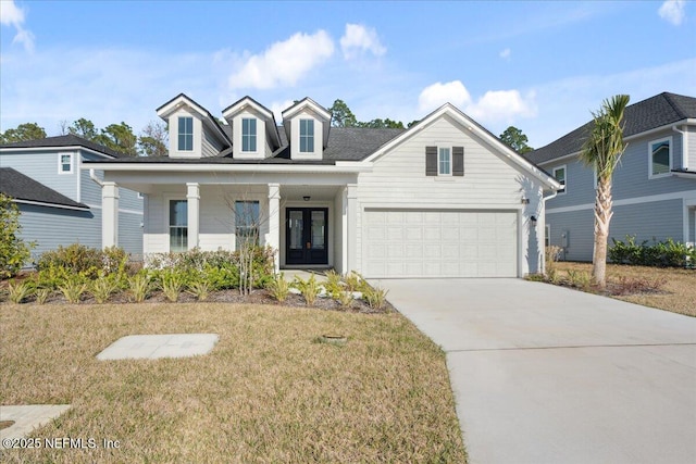 cape cod house with french doors, a garage, concrete driveway, and a front yard