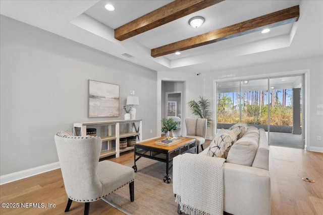 living room with recessed lighting, beamed ceiling, baseboards, and light wood finished floors