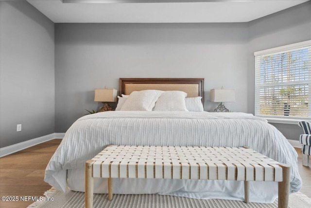 bedroom with baseboards and wood finished floors